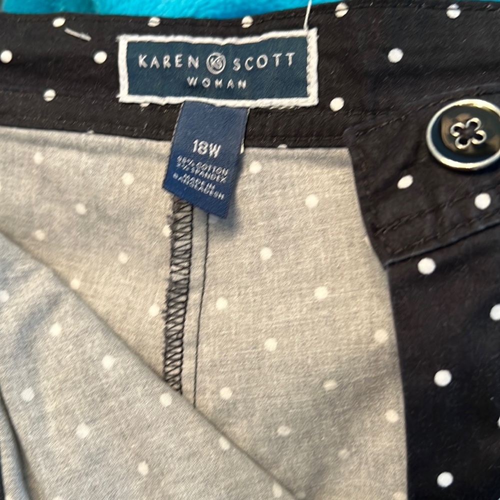 Black skort with polka dots has front pockets and zipper